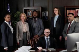 Un groupe diversifié de professionnels du monde des affaires posant dans un bureau, mettant en valeur le travail d'équipe et le leadership.